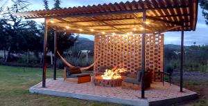 a pavilion with two chairs and a fire pit at El Chasqui Guest House in Chasqui