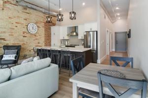 トラバースシティにあるGolden Lofts Unit 1 Downtown Traverse City 1BD 1BAのリビングルーム、キッチン(ソファ、テーブル付)