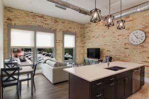 a kitchen and living room with a brick wall at Golden Lofts Unit 1 Downtown Traverse City 1BD 1BA in Traverse City