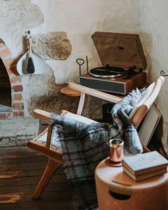 sala de estar con chimenea y silla con fogones en Old World Charm - Simplistic Luxury Cottage, en Ross
