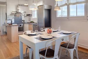 una cocina con una mesa blanca y sillas con gafas en Habitat Apartments Bailén, en Barcelona