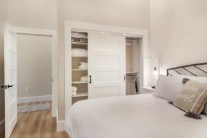 a white bedroom with a bed and a closet at Golden Lofts Unit 2 Downtown Traverse City 1bd 1ba in Traverse City