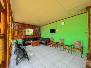 a living room with green walls and chairs and a table at Greenville Hotel Mitra RedDoorz in Sampit