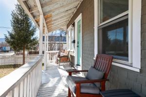 un porche con 2 mecedoras y una ventana en The Wildflower Vacation Cottage, en Colorado Springs