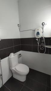 Gopeng Serumah Holiday House في Gopeng: حمام مع مرحاض وهاتف على الحائط