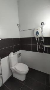 bagno con servizi igienici e telefono appeso al muro di Gopeng Serumah Holiday House a Gopeng Altre 8 foto