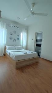 una camera da letto con un letto grande con pavimento in legno di Gopeng Serumah Holiday House a Gopeng