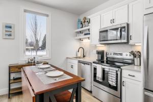 a kitchen with white cabinets and a wooden table at Cypress Parkside Condo in Traverse City