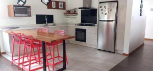 a kitchen with a wooden table and a refrigerator at El Chasqui Guest House in Chasqui