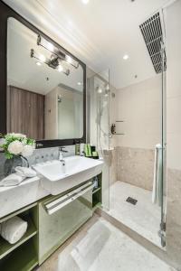 ein Bad mit einem Waschbecken und einer Dusche in der Unterkunft Harbour Plaza Metropolis in Hongkong