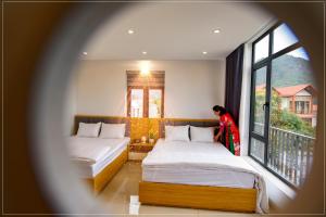 een vrouw in een kamer met twee bedden bij Ninh binh Green Diamond Homestay in Ninh Binh