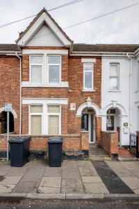 a brick house with two windows and two trash cans at 2-Bed Studio in Bedford-Hospital-VictoriaD in Bedford