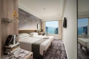 香港にあるハーバー プラザ メトロポリスのベッド2台と大きな窓が備わるホテルルームです。