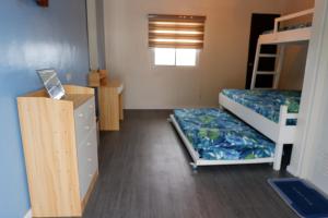 a dorm room with two bunk beds and a dresser at Puffer Isle Resort in Dingalan
