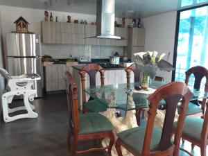 eine Küche mit einem Glastisch und einigen Stühlen in der Unterkunft Finca las palmeras /Cabaña de Ian in San Antonio del Tequendama