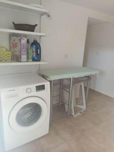 a laundry room with a washing machine and a table at A Casa da Carmita in Pedrógão Grande