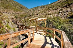 a wooden boardwalk leading up to a mountain at A Casa da Carmita in Pedrógão Grande