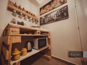una cocina con una estantería con microondas. en CITRUS LUXURY APARTMENT - holiday apartment with up to 3 bedrooms in palermo center, en Palermo