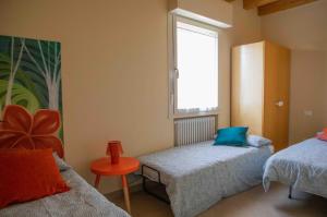 a small bedroom with two beds and a window at Casa con ampio terrazzo, vista lago e giardino in Toscolano Maderno