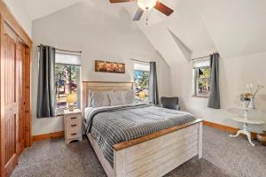 Schlafzimmer mit einem Bett und einem Deckenventilator in der Unterkunft Black Bear Cabin with Hot Tub in Woodland Park