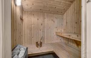 a wooden sauna with a bench in a room at Cozy Home In Hadsund With Sauna in Helberskov +18 photos