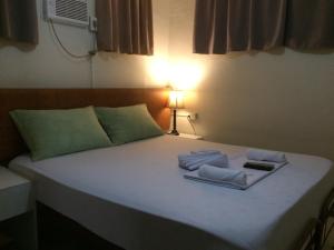 ein Schlafzimmer mit einem Bett mit zwei Handtüchern darauf in der Unterkunft CrisFil's Lodge Incorporated in Dumaguete