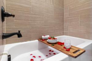 a bathroom with a bath tub with a wooden tray on the side at Black Bear Cabin with Hot Tub in Woodland Park +30 photos