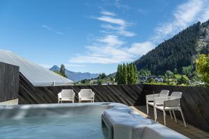 a swimming pool with chairs and a swimming pool at Turner Heights Townhouses in Queenstown