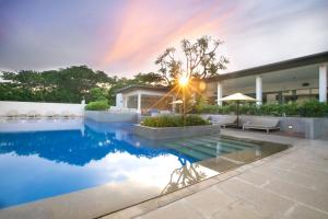 a house with a pool and a rainbow in the sky at BLVD Club - Near BENGALURU AIRPORT in Bangalore