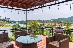 patio con mesa y sillas en el balcón en Sun Villa- Flamingo Venus Đại Lải, en Vĩnh Phúc