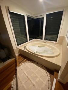 a large bath tub in a room with two windows at Kondalilla Eco Resort in Montville