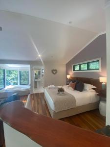 a bedroom with a large bed and two windows at Kondalilla Eco Resort in Montville