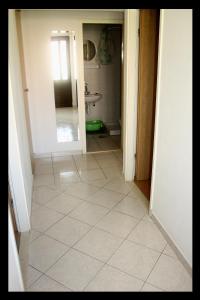 baño con suelo de baldosa blanca y lavamanos en Apartments Boljat, en Supetar