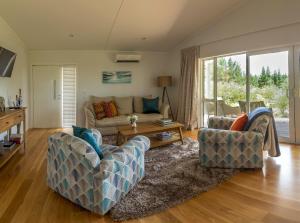 a living room with a couch and two chairs at Treghan Luxury Lodge in Kerikeri