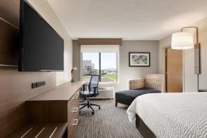 a hotel room with a bed and a desk with a television at Holiday Inn Express Hotel & Suites Anniston/Oxford, an IHG Hotel in Oxford
