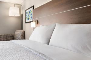 a hotel room with a bed with white pillows at Holiday Inn Express Hotel & Suites Anniston/Oxford by IHG in Oxford