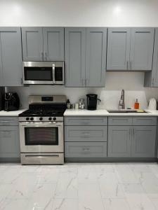 eine Küche mit Küchengeräten aus Edelstahl und weißen Schränken in der Unterkunft Adorable 2 bedroom with free street parking in Chicago