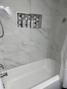 ein weißes Bad mit einer Badewanne und einer Dusche in der Unterkunft Adorable 2 bedroom with free street parking in Chicago