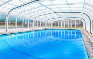 uma piscina interior com tecto de vidro em Gorgeous Home In Risr With House A Panoramic View em Risør