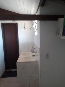 uma casa de banho com um lavatório e uma porta castanha em OTIMO APARTAMENTO EM JACARAIPE ES ! em Serra