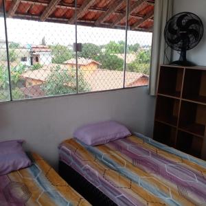 um quarto com uma cama e uma grande janela em OTIMO APARTAMENTO EM JACARAIPE ES ! em Serra
