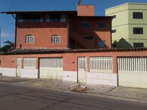 a building with gates on the side of a street at OTIMO APARTAMENTO EM JACARAIPE ES ! in Serra
