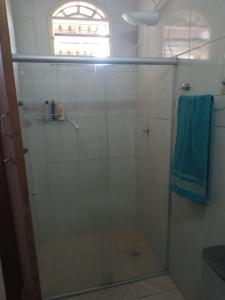 eine Dusche mit Glastür und blauem Handtuch in der Unterkunft OTIMO APARTAMENTO EM JACARAIPE ES ! in Serra