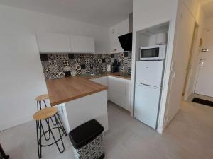 cocina con armarios blancos y nevera blanca en Studio Marseillan-Plage, 1 pièce, 4 personnes - FR-1-326-781, en Marseillan