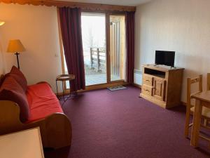Cette chambre comprend un lit, une télévision et une fenêtre. dans l'établissement Appartement cosy à Orcières avec parking et WIFI gratuit, 4 personnes - FR-1-636-218, à Orcières