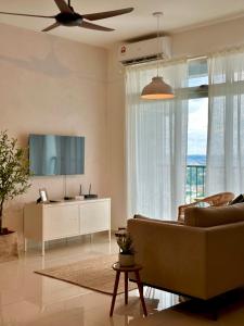 a living room with a couch and a television at Wabi-Sabi Guesthouse At Ipoh Town 侘寂风民宿 in Ipoh