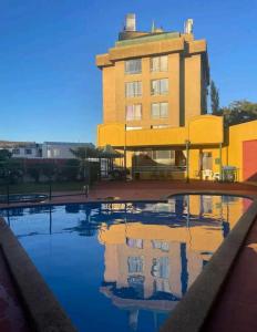 a building with a pool in front of a building at Departamento Centro Temuco 3D, 2B, Familiar, Piscina, Estacionamiento in Temuco