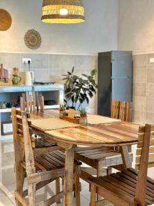 uma cozinha com uma mesa de madeira e cadeiras em Wabi-Sabi Guesthouse At Ipoh Town 侘寂风民宿 em Ipoh