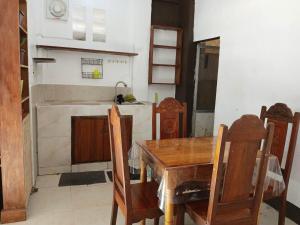 a kitchen with a wooden table and chairs and a sink at DGA Pension House in Coron