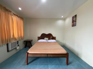 ein Schlafzimmer mit einem Bett in der Ecke eines Zimmers in der Unterkunft Balay Inato Pension in Puerto Princesa